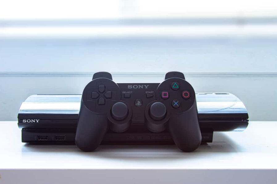 Playstation PS3 з пультом дистанційного керування на білому столі