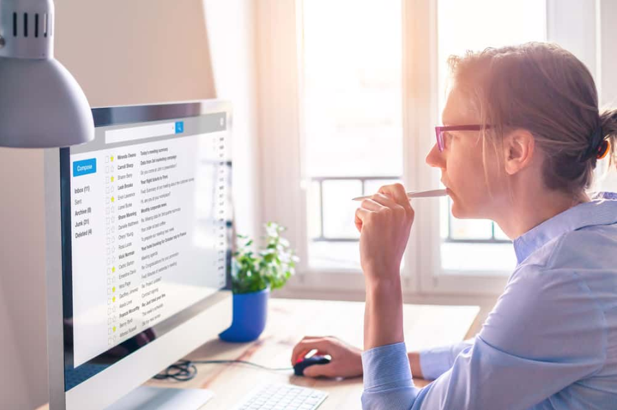 Ділова людина читає електронну пошту на екрані комп'ютера на роботі в Інтернеті