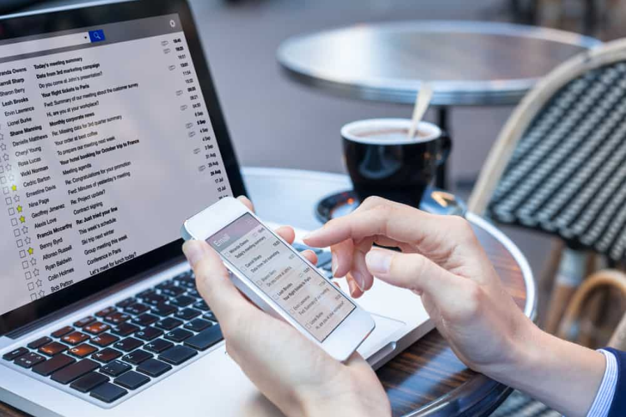 Ділова людина читає електронні листи на екрані комп'ютера смартфона та ноутбука в Інтернеті, комунікаційна та маркетингова концепція