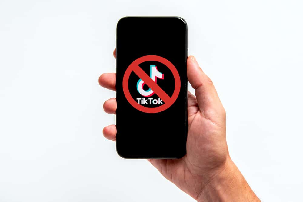 Чоловік тримає мобільний телефон із додатком Tik Tok заборонено