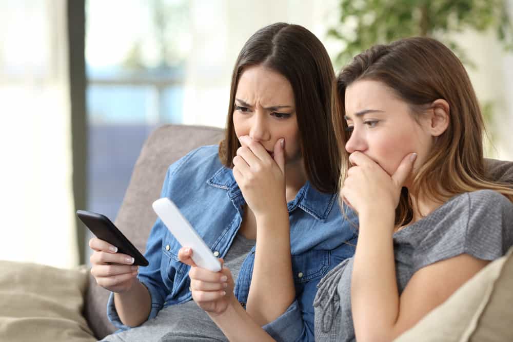 Дві стурбовані жінки перевіряють вміст смартфонів