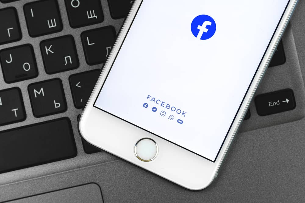 Програма Facebook на екрані Apple iPhone, фон клавіатури, фото