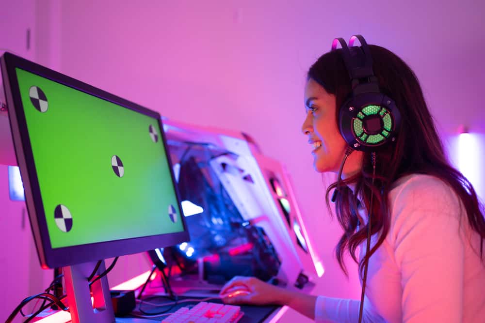 гравець, який носить ігрову гарнітуру, сидить на стільці та грає в онлайн-ігри
