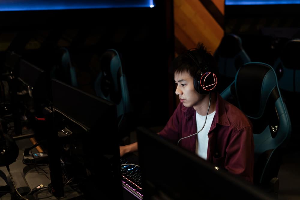 геймер грає на комп'ютері в інтернет-кафе з серйозним виглядом