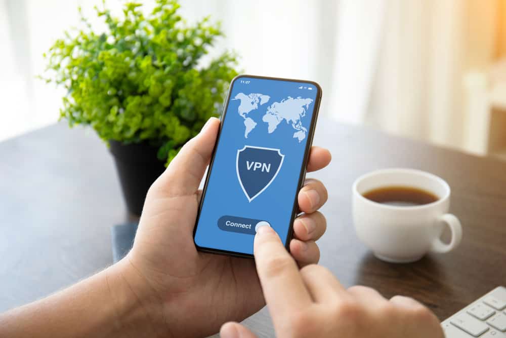 руки тримають телефон із програмою vpn