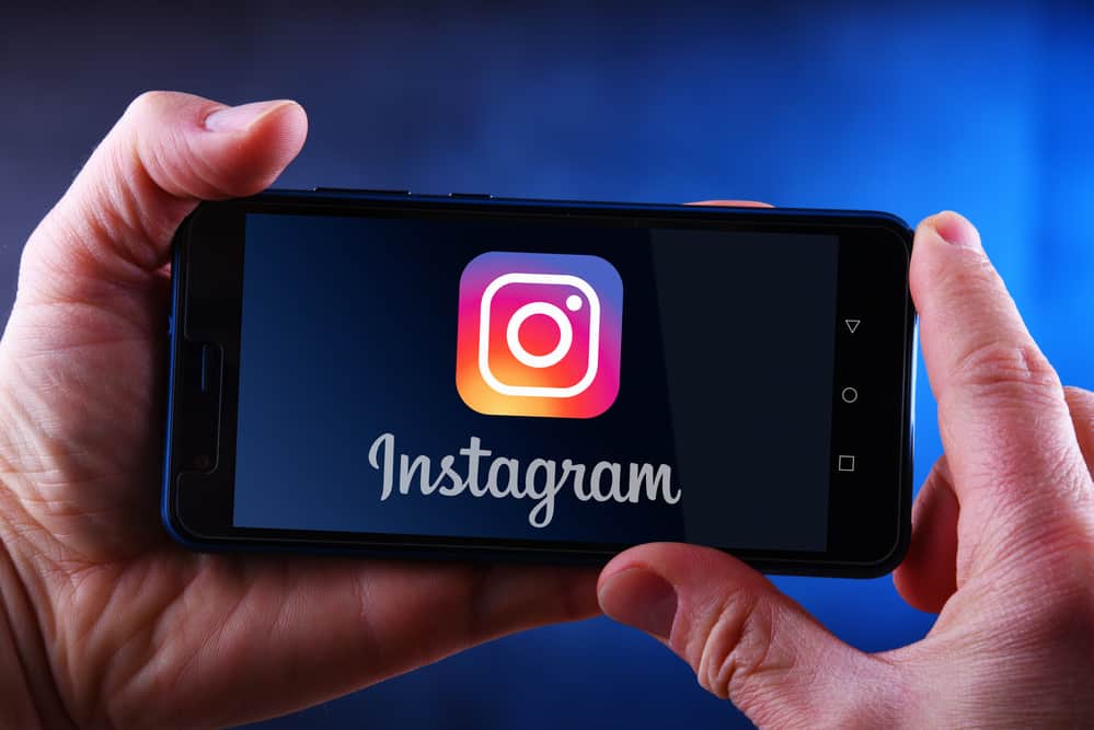 Руки тримають смартфон із логотипом instagram