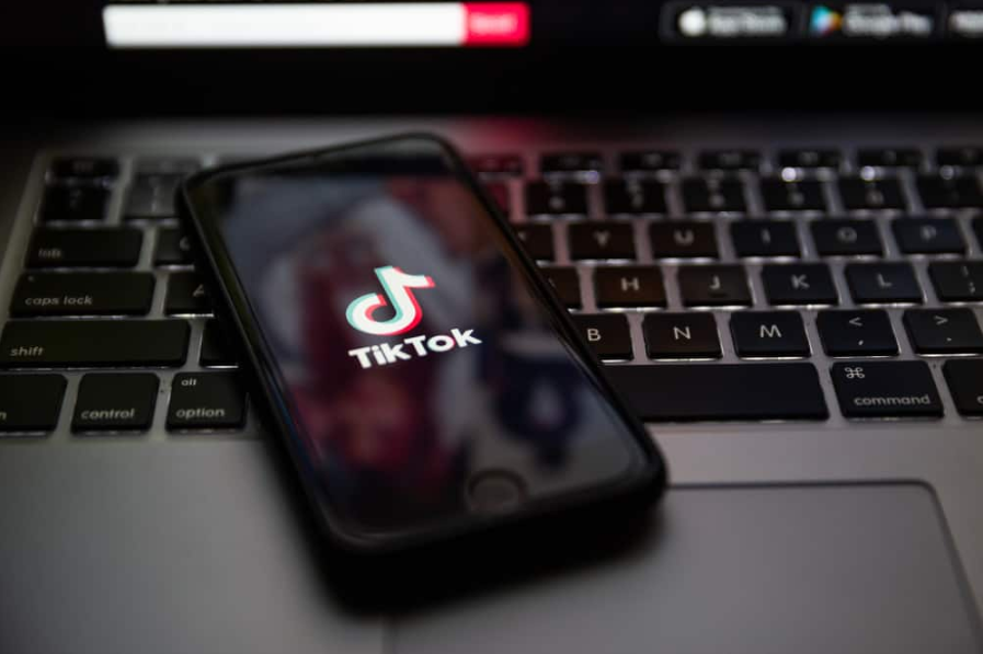 Логотип бренду TikTok на екрані Apple iPhone 7 увечері