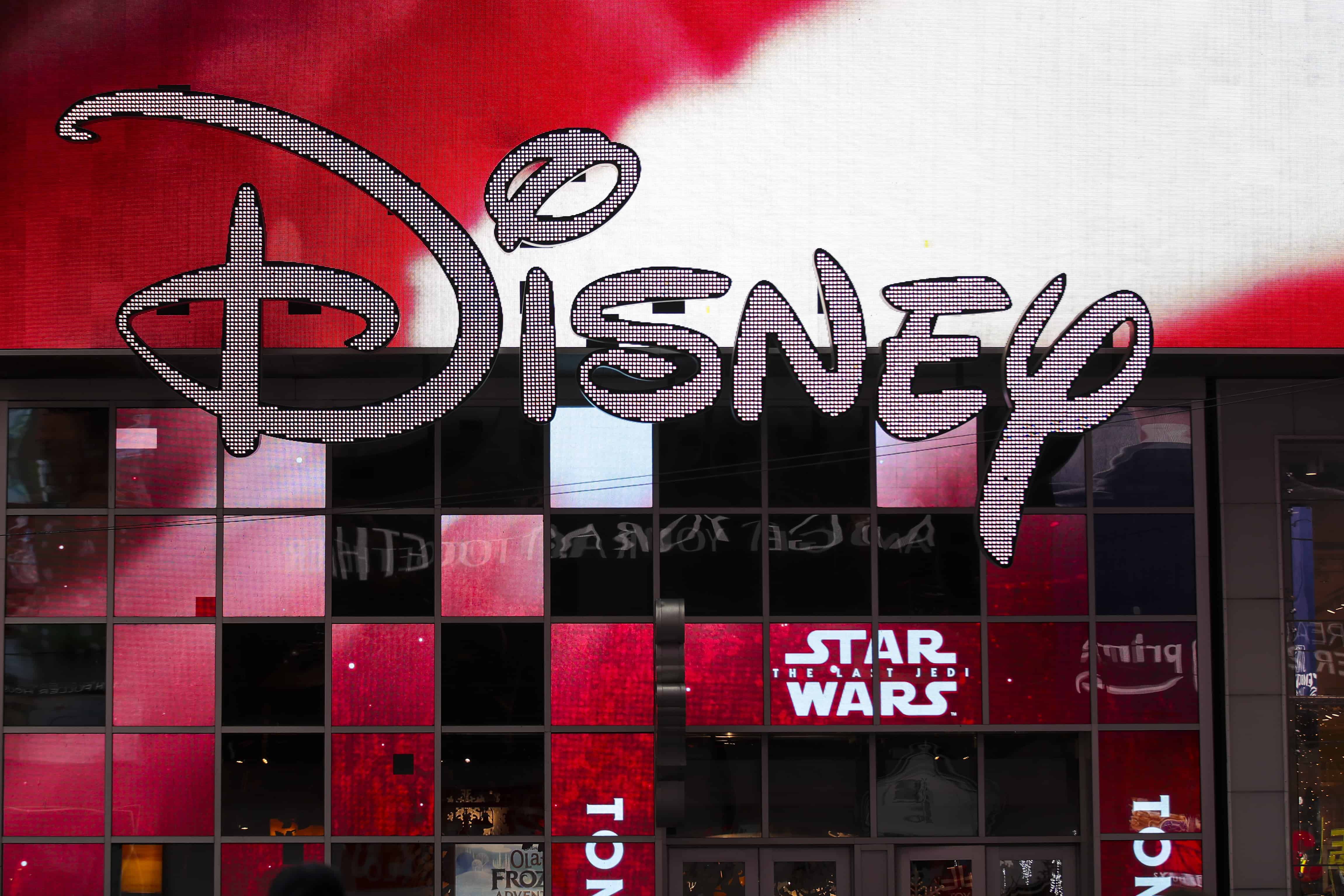 Логотип Disney виставлений біля Disney Store на Таймс-сквер, 14 грудня 2017 року в Нью-Йорку. У четвер вранці компанія Walt Disney оголосила, що досягла угоди про купівлю більшості активів 21st Century Fox. Загальна вартість угоди становить близько 66 мільярдів доларів, при цьому Disney візьме на себе 13,7 мільярда доларів чистого боргу Fox.