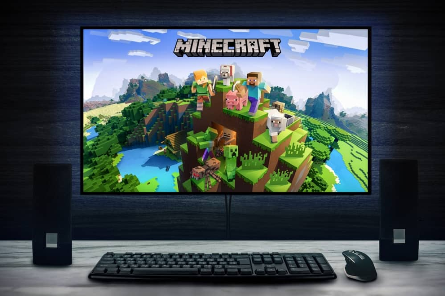 Логотип відеоігри Minecraft на екрані ПК з клавіатурою, мишею та динаміками.