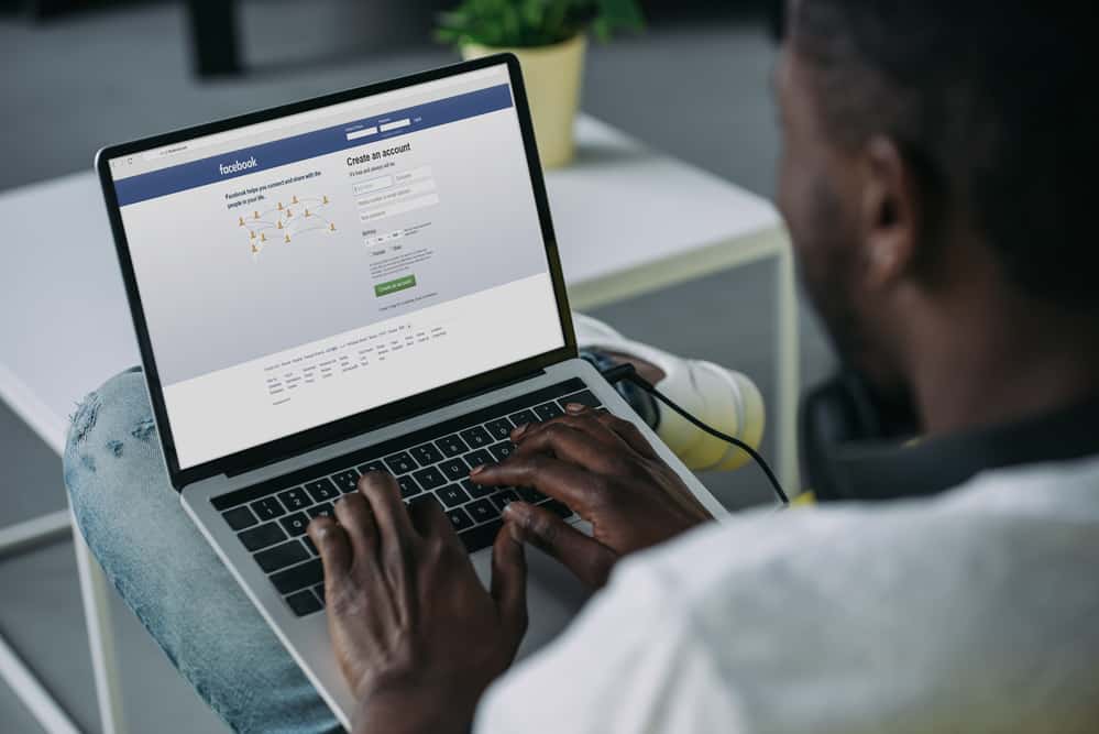 Чоловік використовує Facebook на ноутбуці