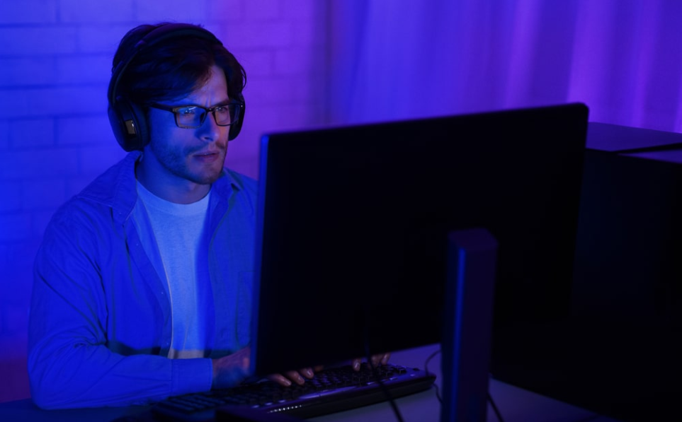 Людина перед комп'ютером, використовуючи комп'ютер пізно вночі