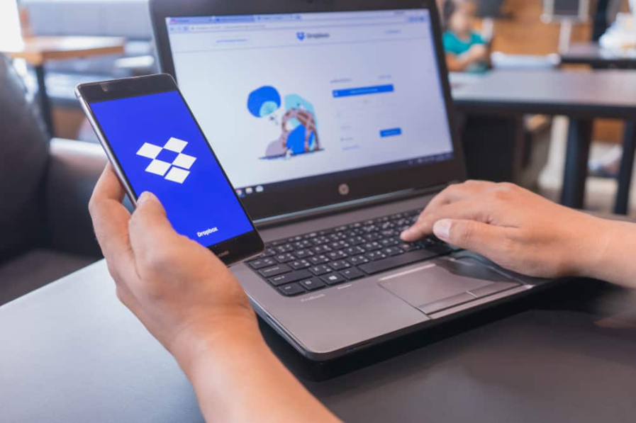 Руки людини тримають HUAWEI з Dropbox на екрані