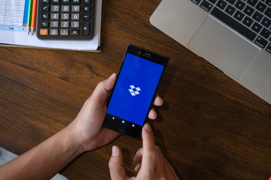 Чоловік тримає Dropbox