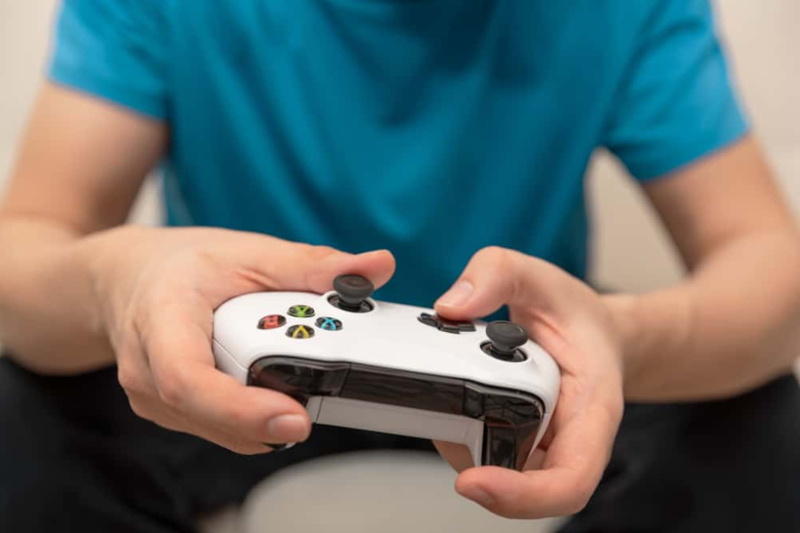 Чоловік тримає ігровий планшет Microsoft XBOX One X