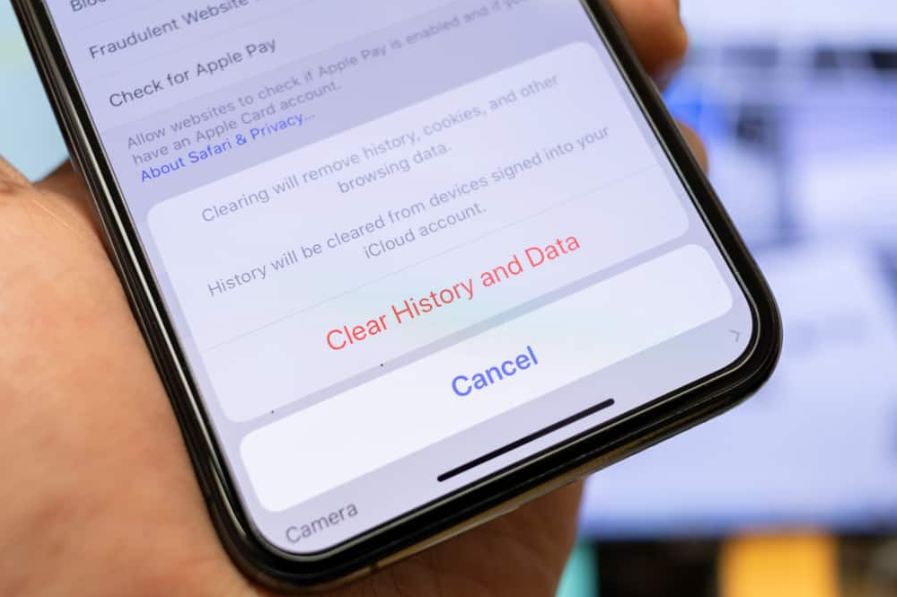 чоловік тримає смартфон, щоб очистити історію веб-переглядача з мобільного браузера apple safari