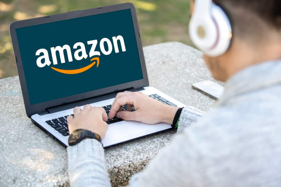 Людина в парку з комп'ютером з логотипом Amazon