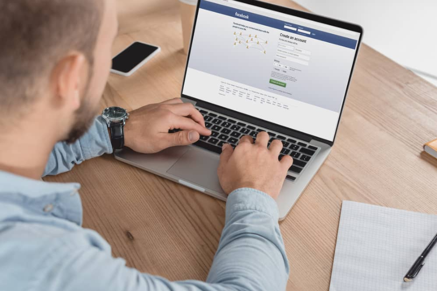 Людина за допомогою ноутбука та facebook