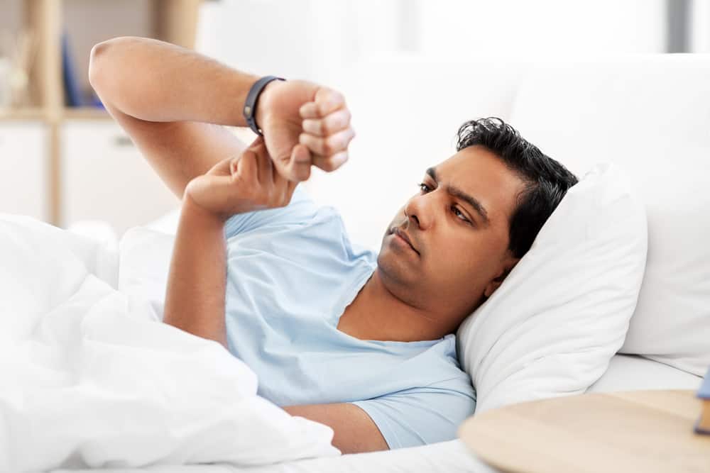 людина з трекером здоров'я в ліжку