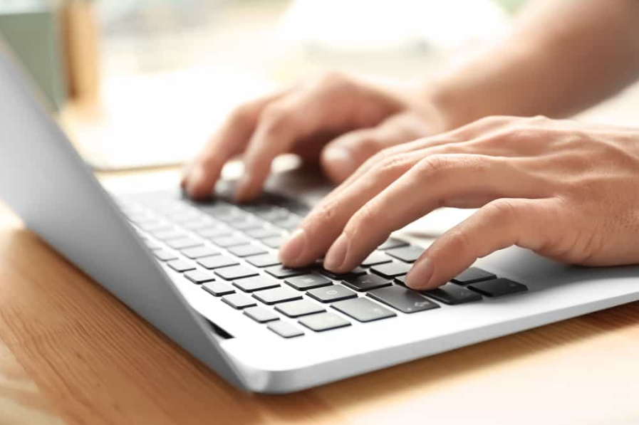 Чоловік використовує ноутбук на столі, крупним планом