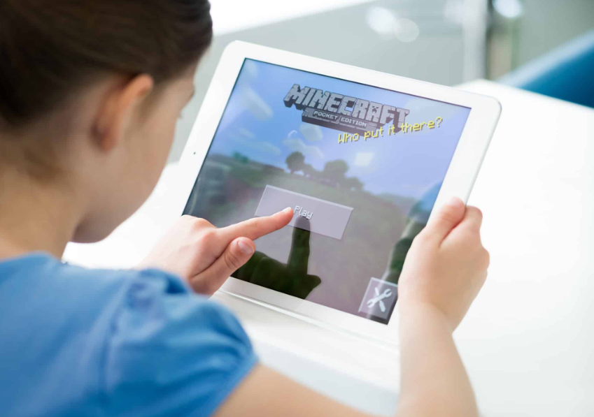 Маленька дівчинка грає в Minecraft на Apple iPad Air