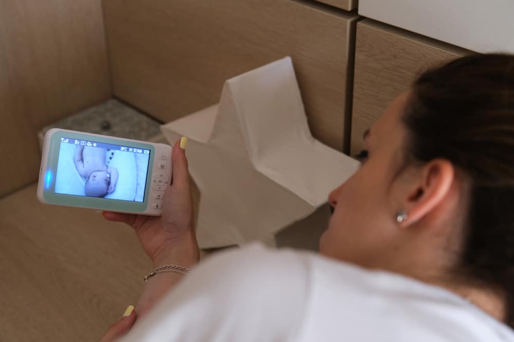 Мати спостерігає за дитиною з монітора