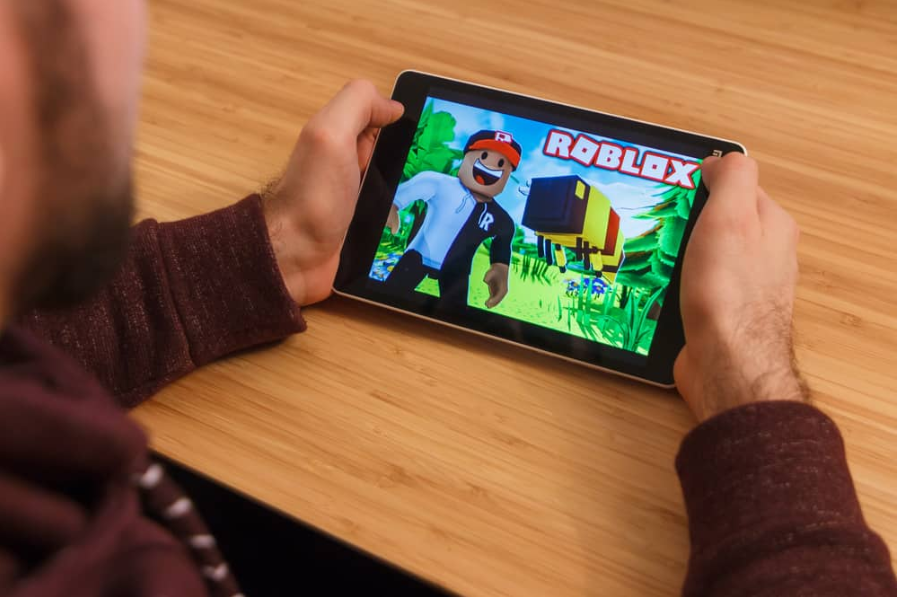 Mna тримає ipad із грою Roblox