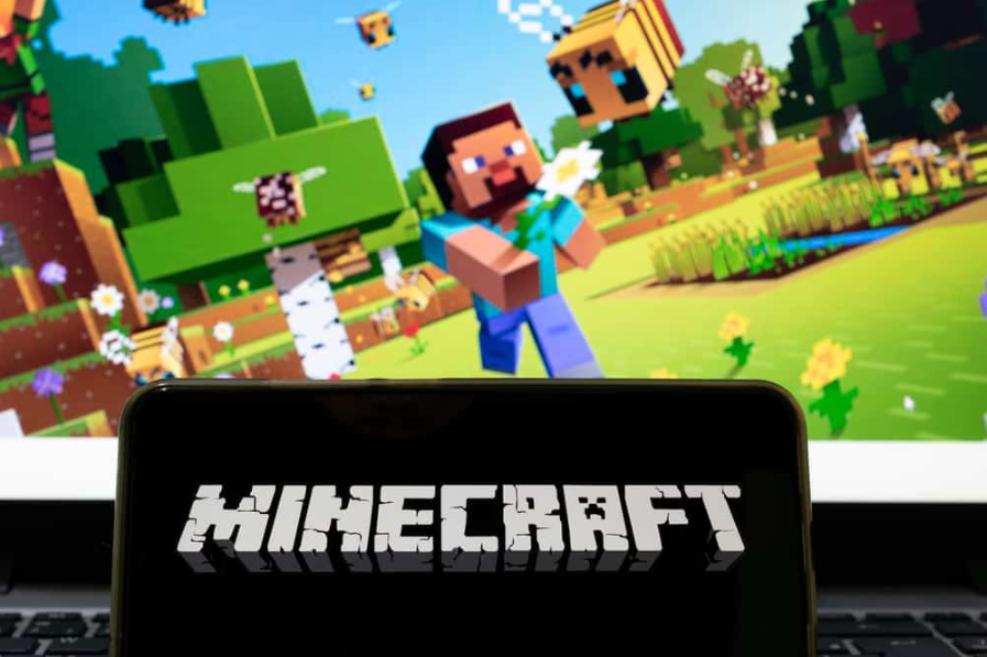 мобільний телефон із назвою гри Minecraft і фоновим екраном, розмитим програмою гри