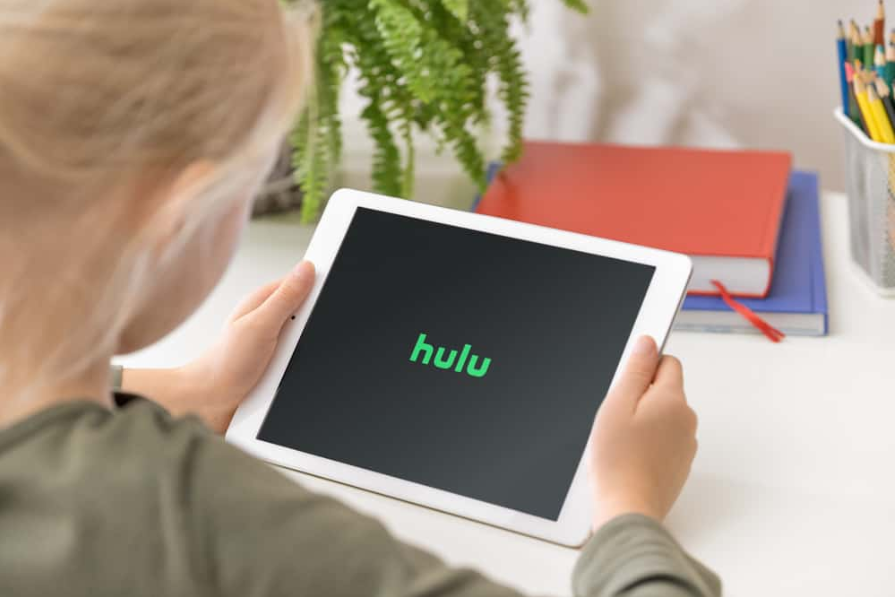 Молода дівчина тримає в руках iPad із застосунком Hulu