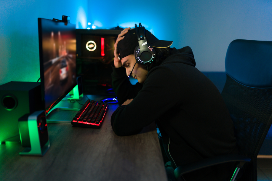 Іспаномовний молодий гравець сумує перед комп'ютером