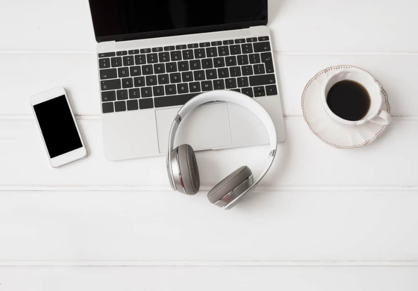 Навушники, портативний комп'ютер, мобільний телефон і чашка кави