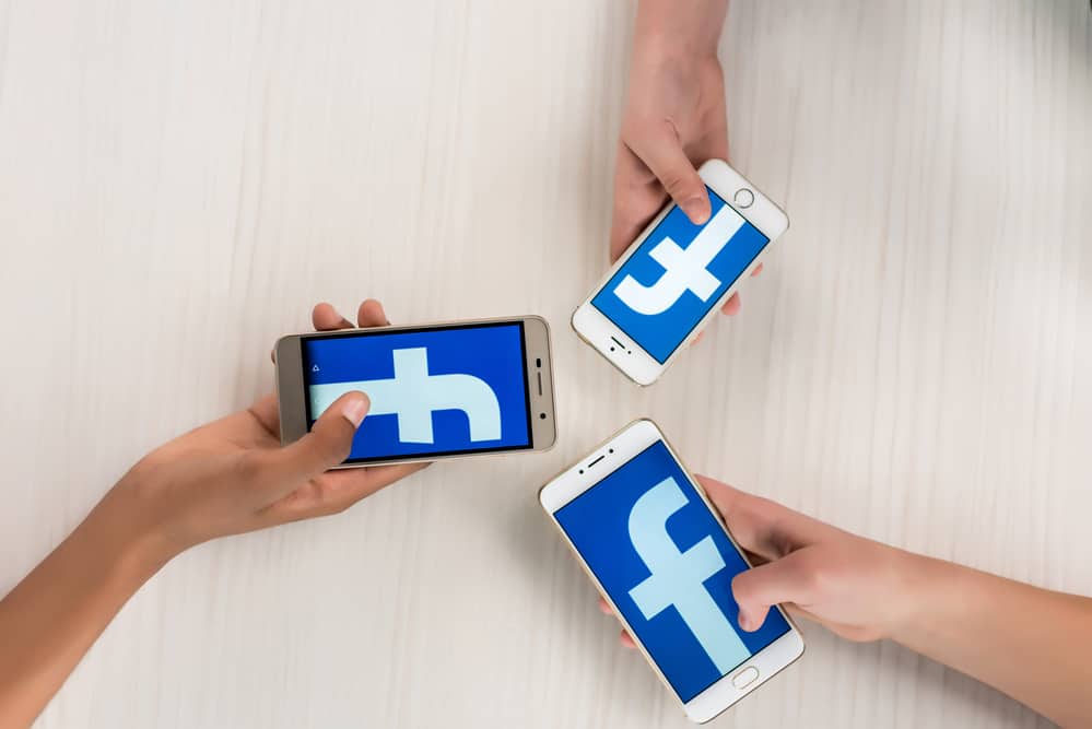 Підлітки тримають смартфони з програмою facebook