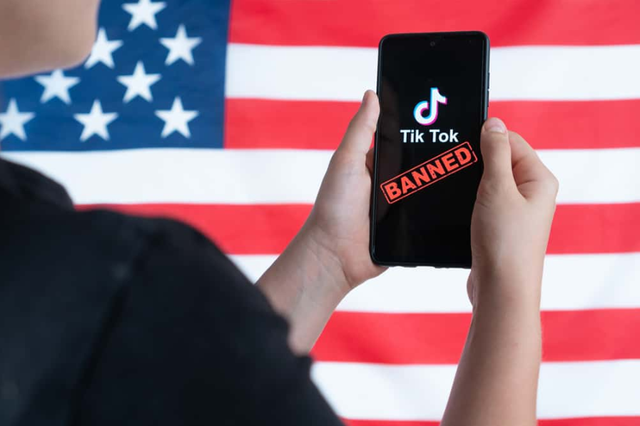 Підліток тримає смартфон із логотипом Tiktok