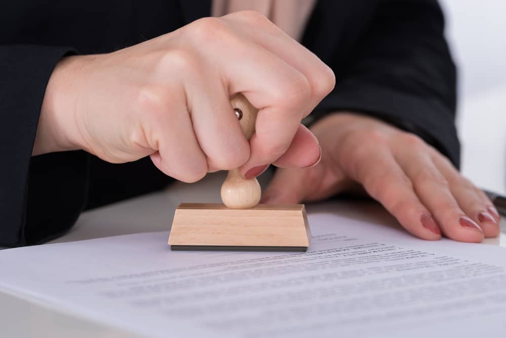 Бізнесмен, використовуючи штамп на документі