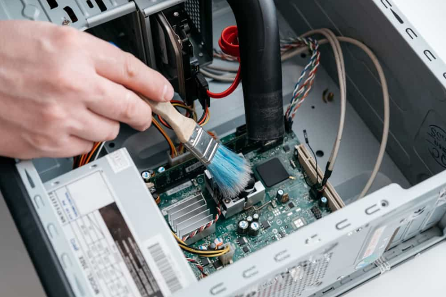 професійний ремонтник тримає щітку для чищення всередині старого персонального комп'ютера