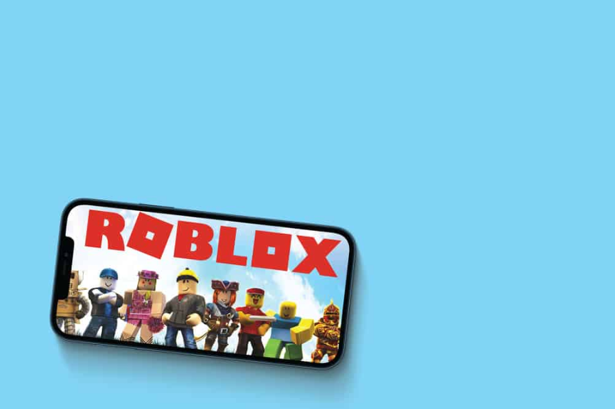 Ігровий додаток Roblox на екрані смартфона на блакитному тлі