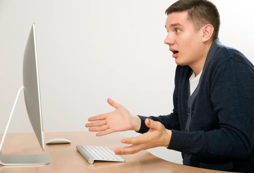 Сердитий чоловік кричить на екрані комп'ютера