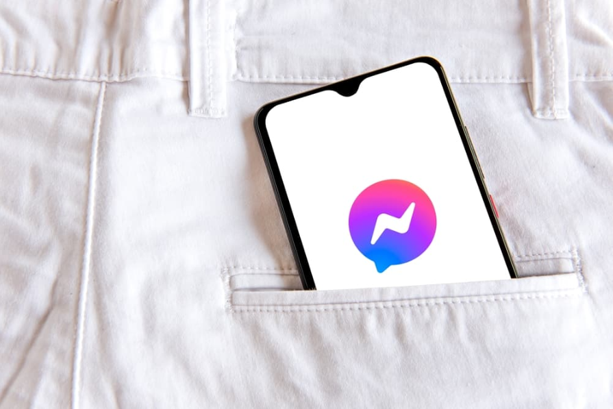 Смартфон із додатком facebook messenger у білих джинсах