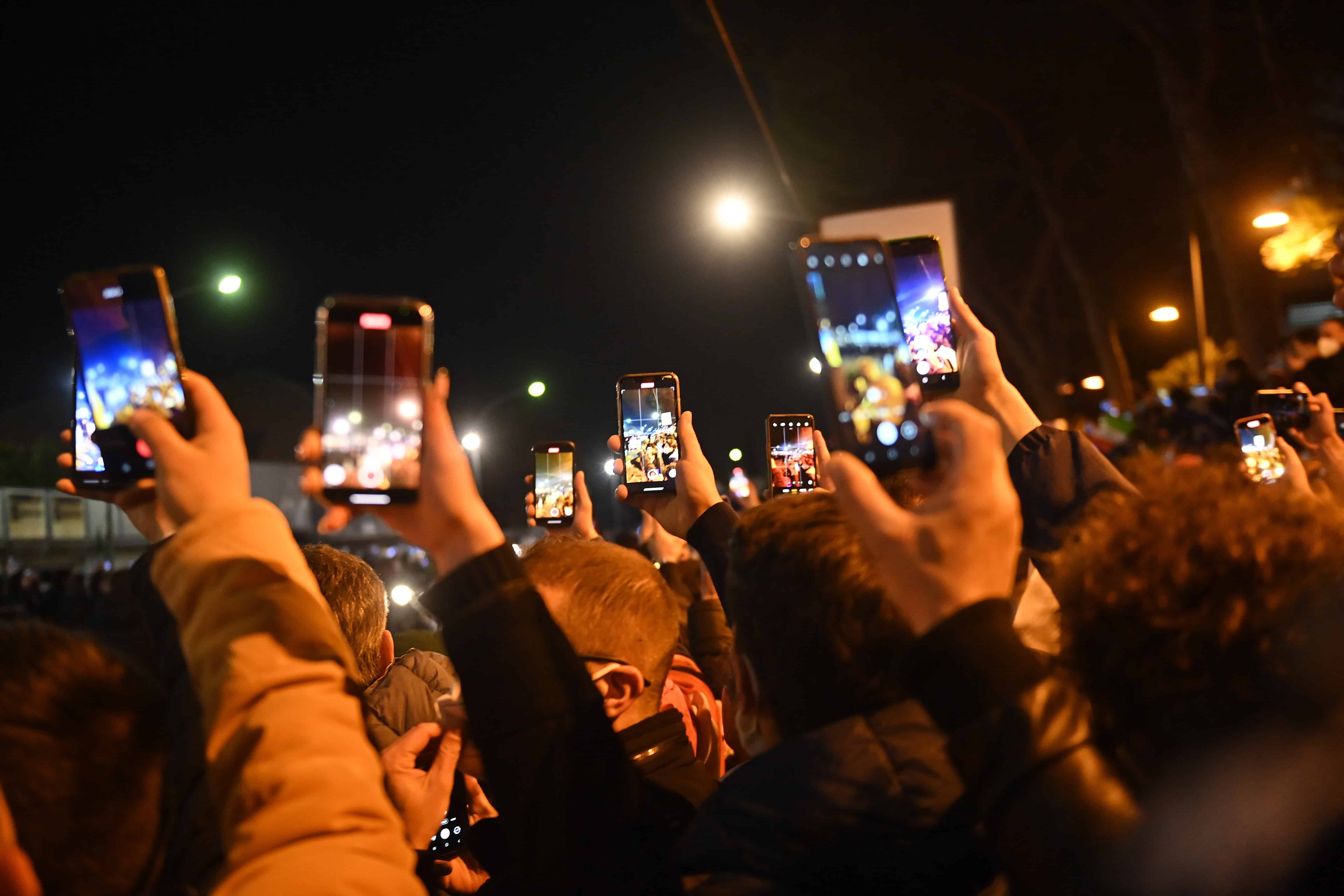 Італійські вболівальники тримають смартфони, коли збірна Італії прибуває на стадіон перед матчем плей-офф плей-офф відбіркового раунду Чемпіонату світу з футболу 2022 між Італією та Північною Македонією на стадіоні Ренцо Барбера в Палермо, Італія