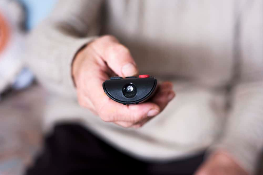 Стара жінка за допомогою пульта дистанційного керування