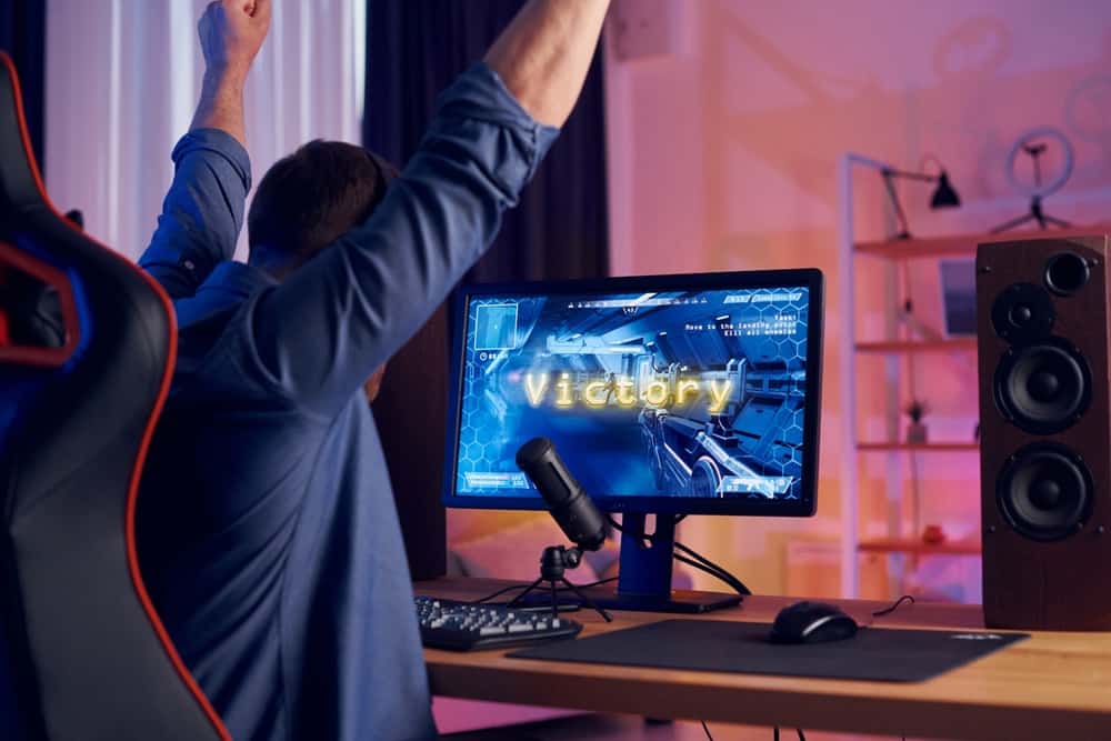 Святкування перемоги. Онлайн-стример, який грає в шутер FPS вдома.