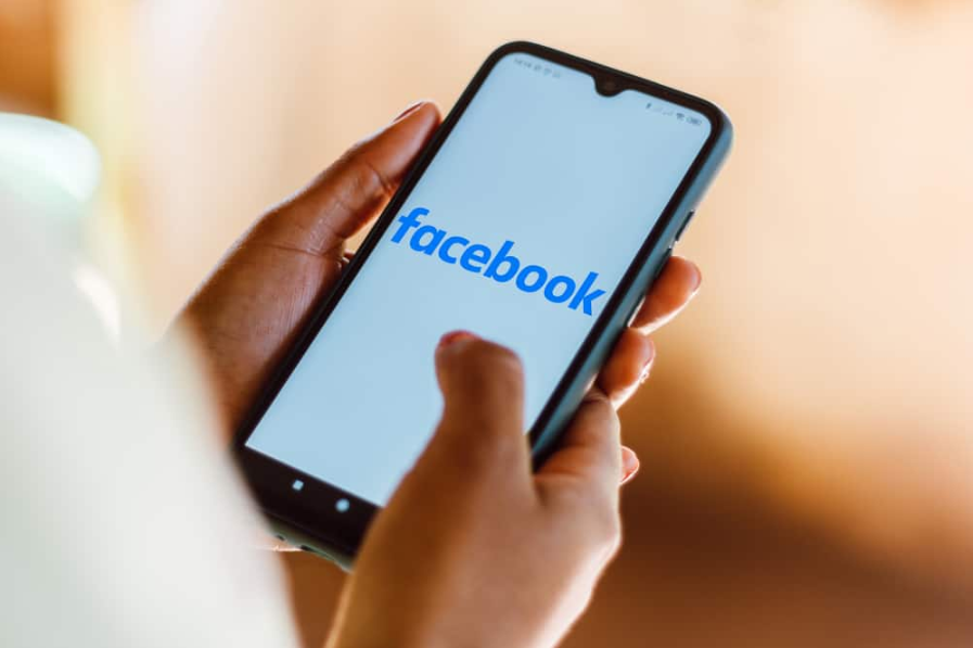 Тримаючи телефон з Facebook