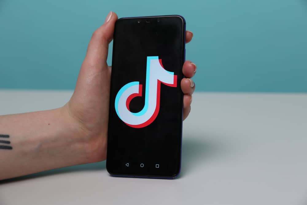 тримаючи телефон із додатком tiktok