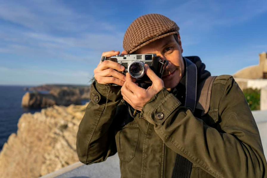 Турист із камерою Leica M2 зі скелями позаду
