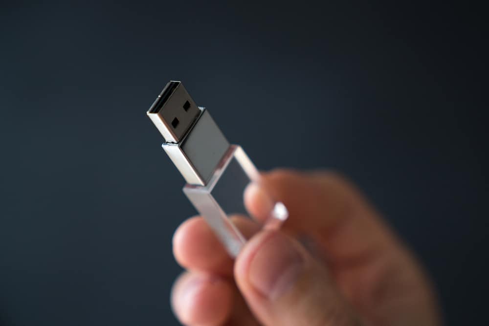 USB-накопичувач у руці на чорному тлі
