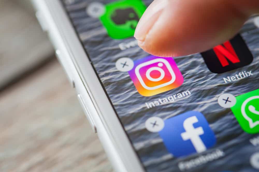 Крупним планом видалення Instagram пальцем на екрані iPhone 7 Plus