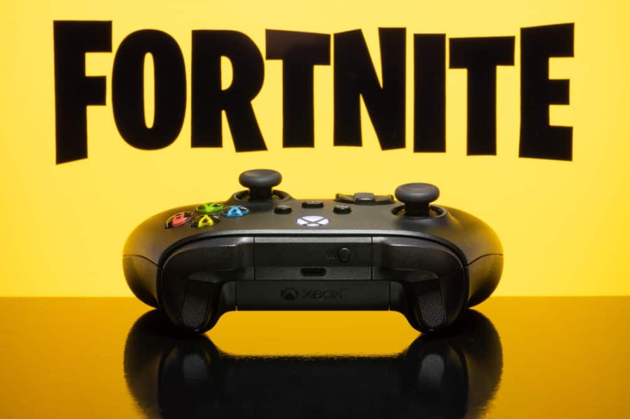 Контролер серії Xbox із логотипом Fortnite на екрані телевізора, вибірковий фокус