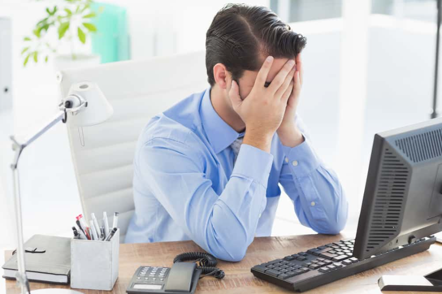 Засмучений бізнесмен ховає обличчя в офісі