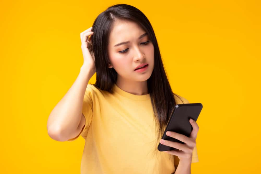 жінка заплутатися і розчаруватися застосування покупки онлайн Дівчина тримати мобільний телефон