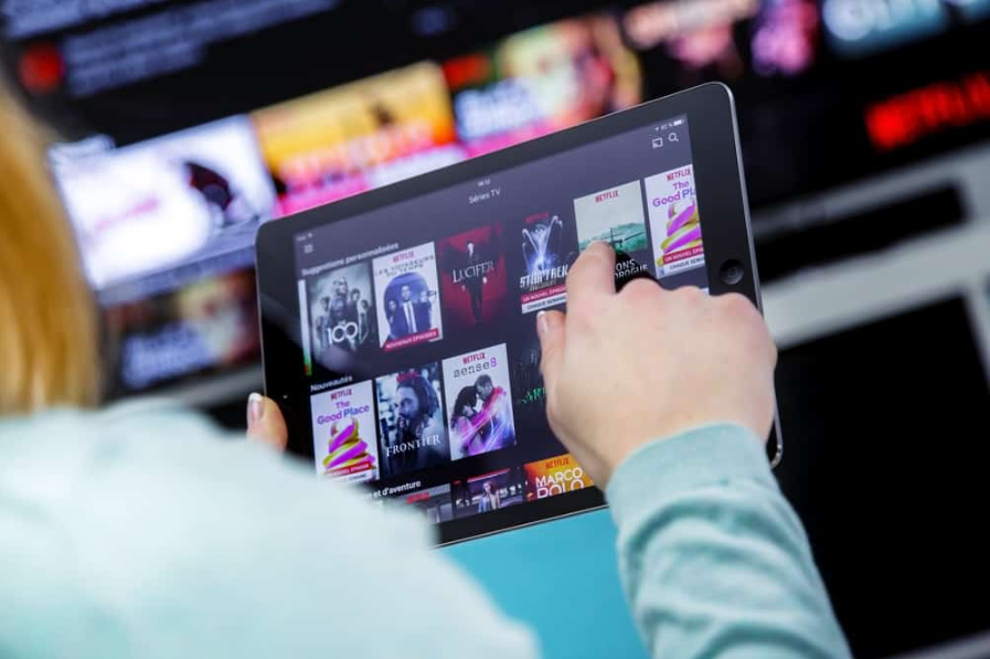 жінка тримає ipad з netflix
