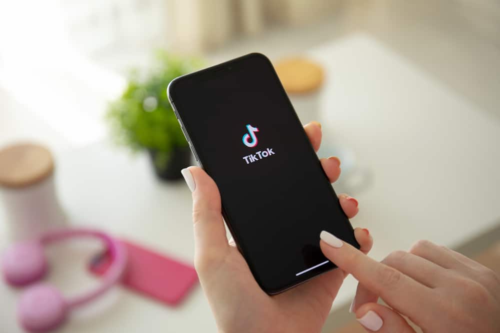Жінка тримає iPhone X потокового медіасервісу